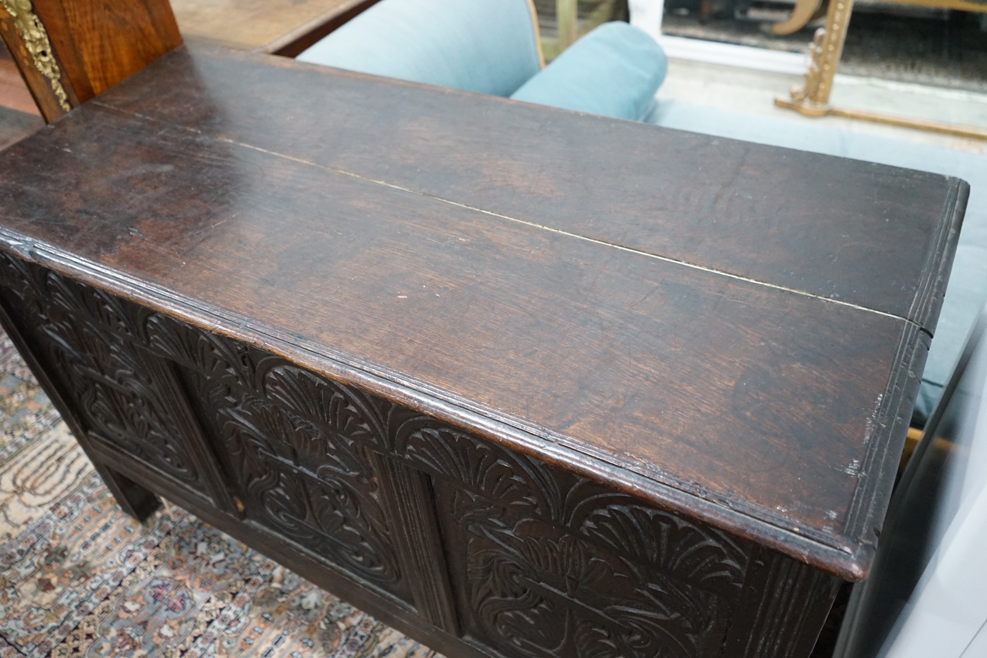 An 18th century carved, panelled oak coffer, width 130cm, depth 57cm, height 78cm